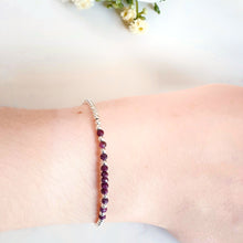 Load image into Gallery viewer, Rich red ruby gemstones in the centre of a silver bead bracelet