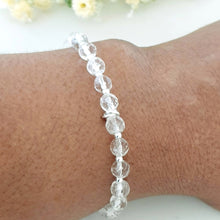 Load image into Gallery viewer, 6mm faceted clear crystal quartz stretch bracelet with sterling silver beads and linked rings in the centre
