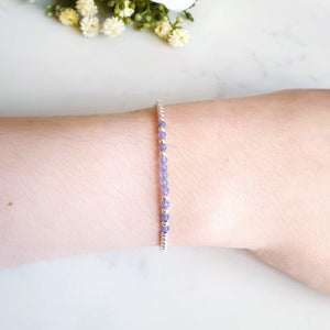 Silver beaded bracelet with purple/blue beaded gemstones in the centre