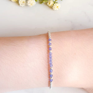 Silver bead bracelet with purple/blue gemstones in the centre of the bracelet
