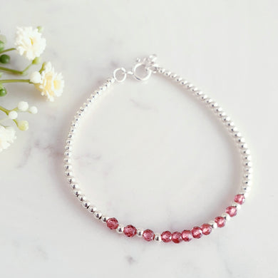 Red beaded gemstone in the centre of sterling silver beads