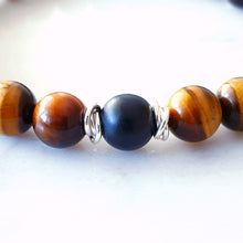 Load image into Gallery viewer, close up of 8mm tigers eye and matt black agate stretch bracelet with sterling rings to show matt black agate in the centre
