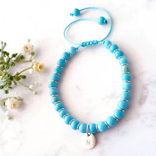 Load image into Gallery viewer, Blue beaded bracelet with rings in between each bead a personalised circle charm. Adjustable cord bracelet.
