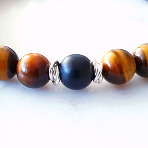 Close up of 8mm tigers eye and matt black agate stretch bracelet with sterling rings to show matt black agate in the centre