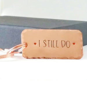 Copper keyring, hand stamped I STILL DO, with red hearts. 40mm x 20mm, textured around the edges. Large and small split rings.