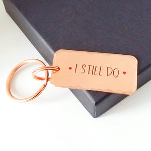 Copper keyring, hand stamped I STILL DO, with red hearts. 40mm x 20mm, textured around the edges. Large and small split rings.