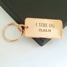 Load image into Gallery viewer, Personalised copper keyring, hand stamped I STILL DO, with the option to add your anniversary date.  Keyring is 45mm x 25mm, textured around the edges and comes with small and large copper finish split rings.  
