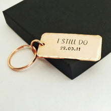 Load image into Gallery viewer, Personalised copper keyring, hand stamped I STILL DO, with the option to add your anniversary date.  Keyring is 45mm x 25mm, textured around the edges and comes with small and large copper finish split rings.  
